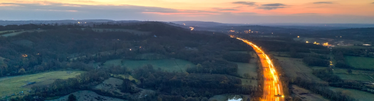 Photograph with long exposure setting to show car lights on the motorway through the countryside Photograph with long exposure setting to show car lights on the motorway through the countryside