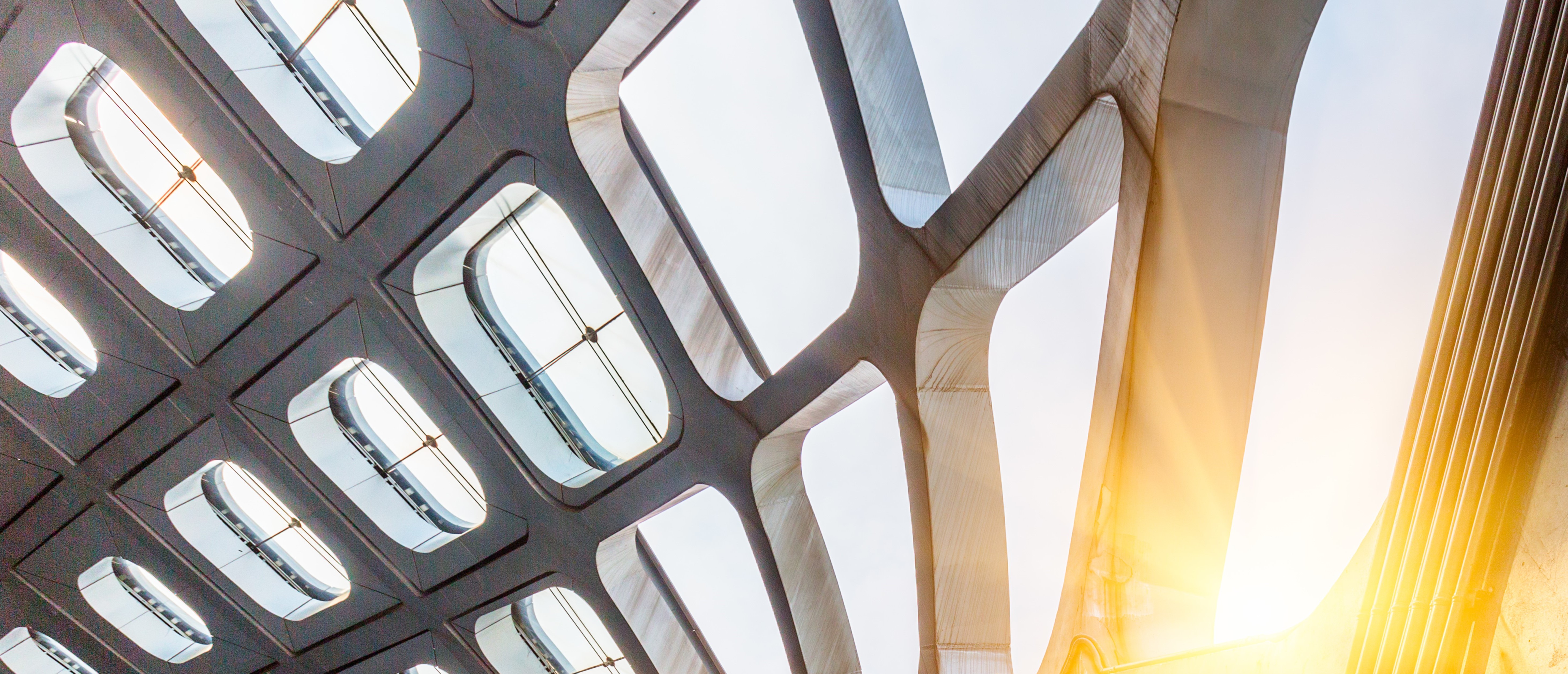 Close-up view of a contemporary building facade featuring glass panels and steel beams. 