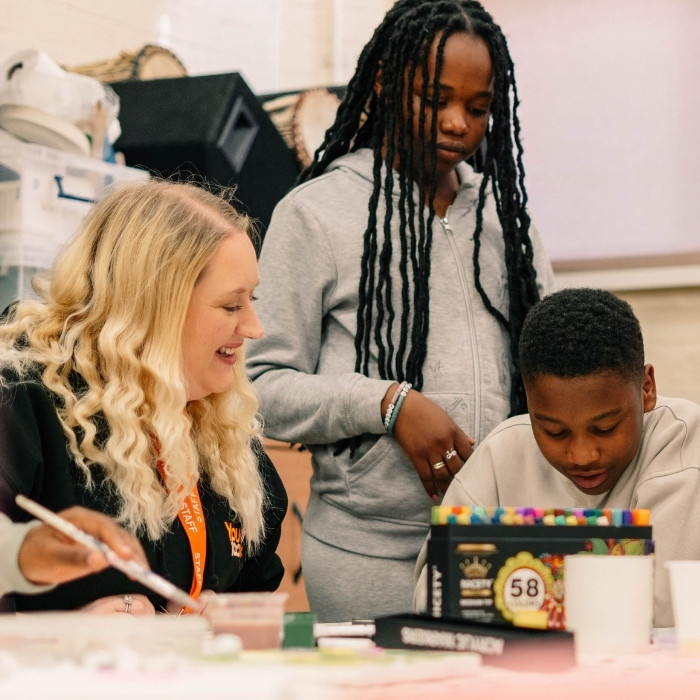 Two young people working on a project with a community leader. 