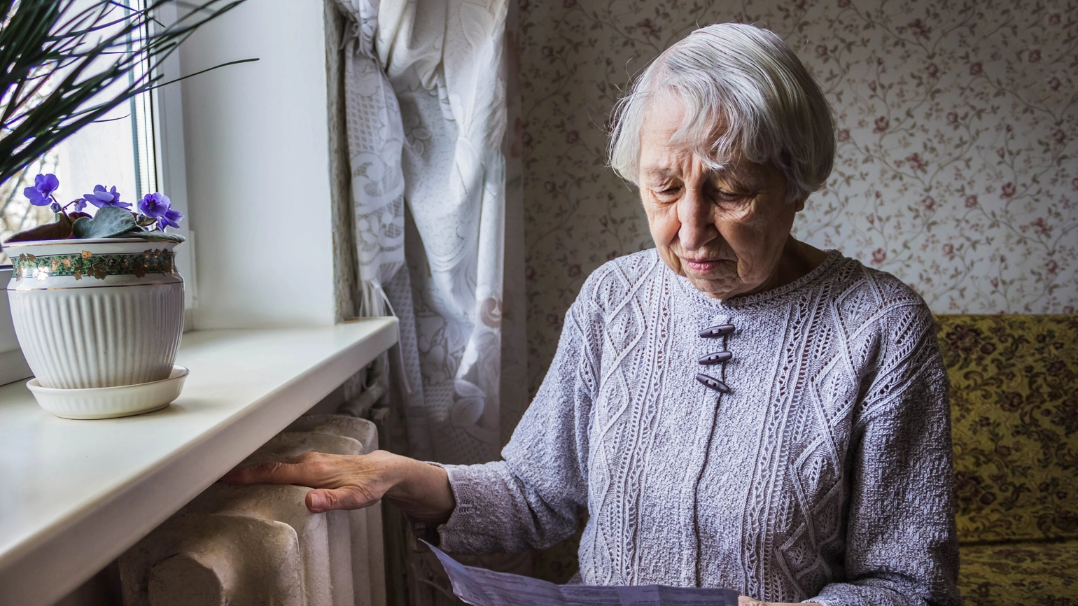 Older person looking at a paper letter Older person looking at a paper letter
